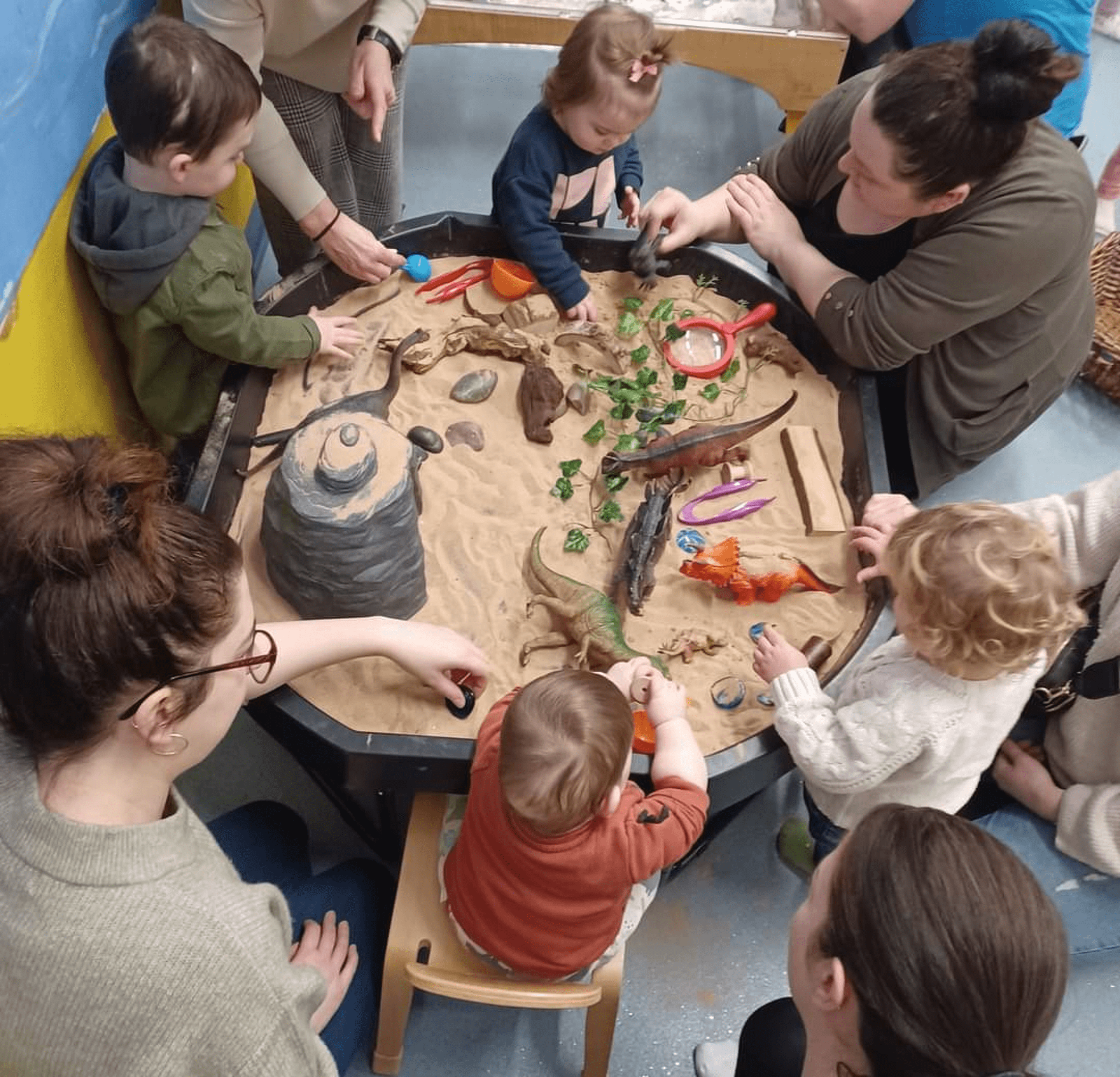 Families playing together with dinosaurs