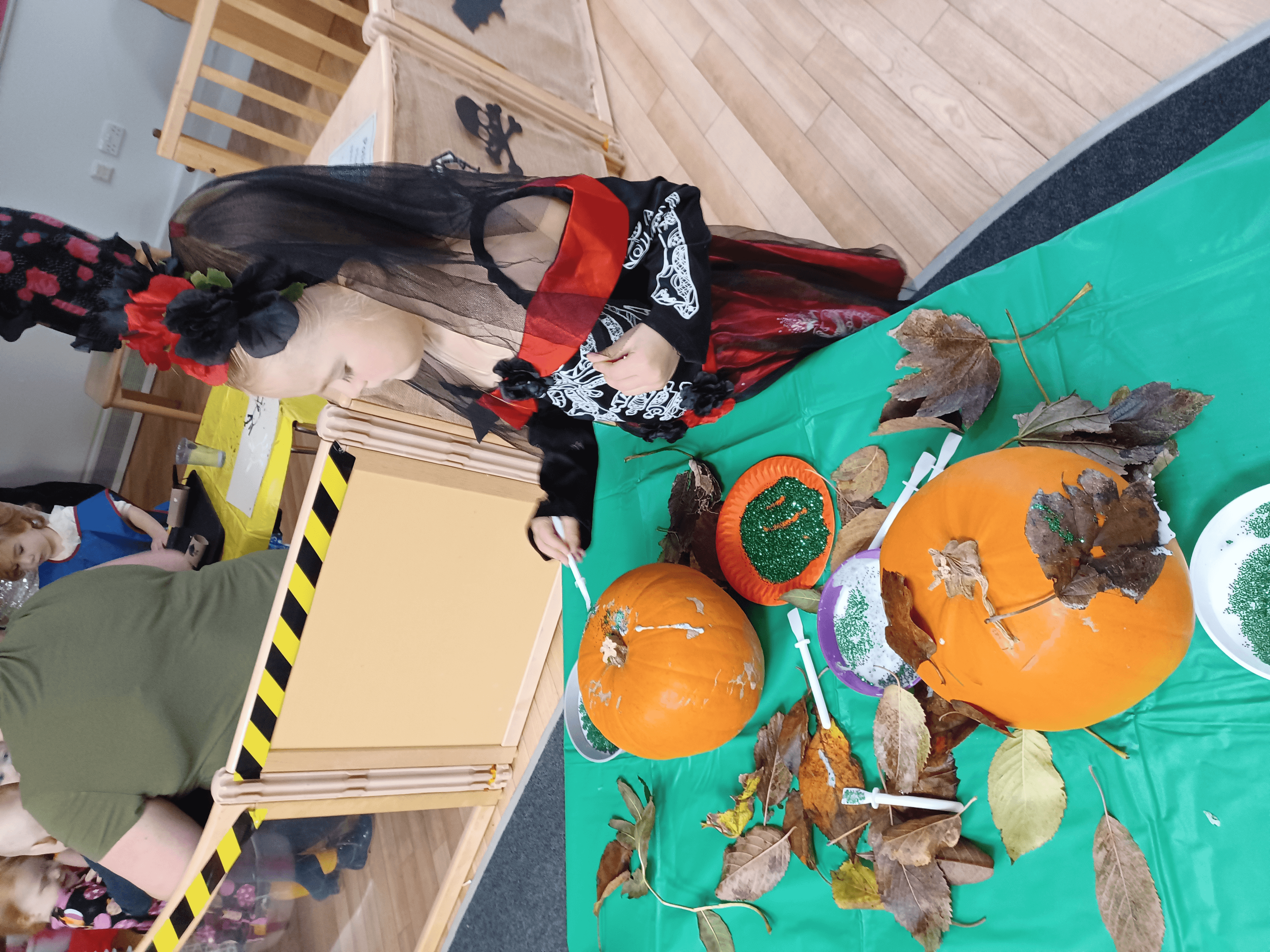 Child dressed up decorating a pumpkin