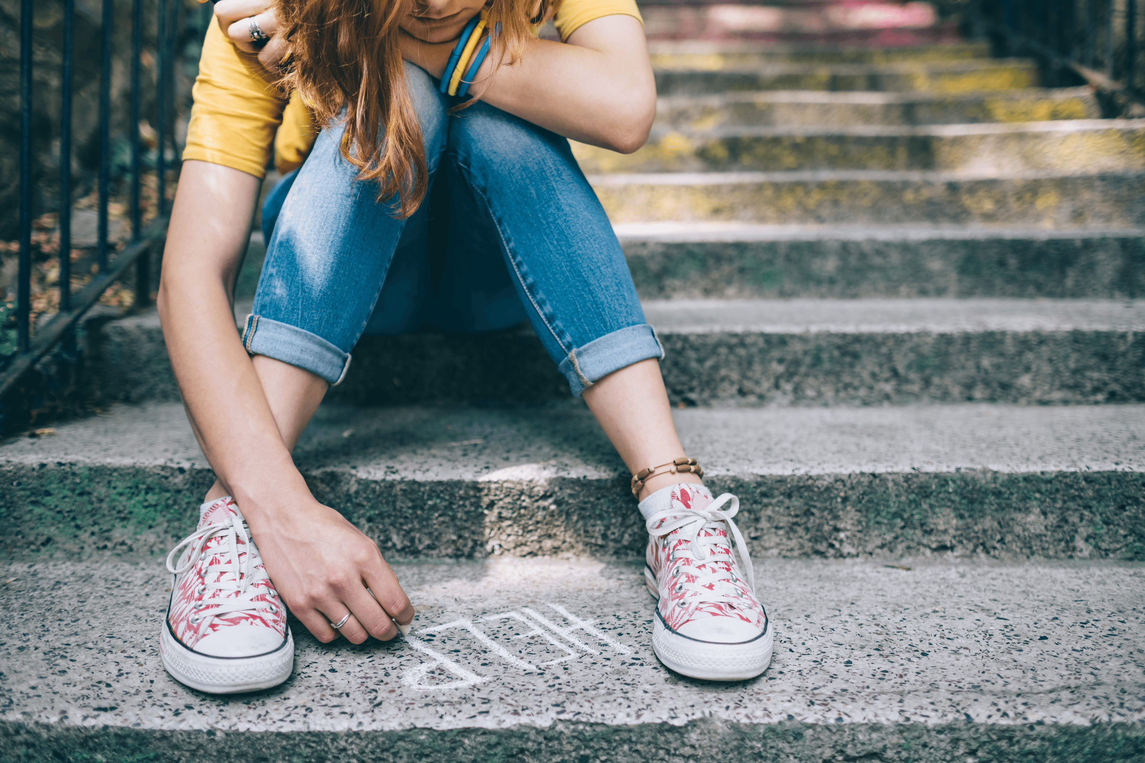 Teenage girl sitting on stairs writing help