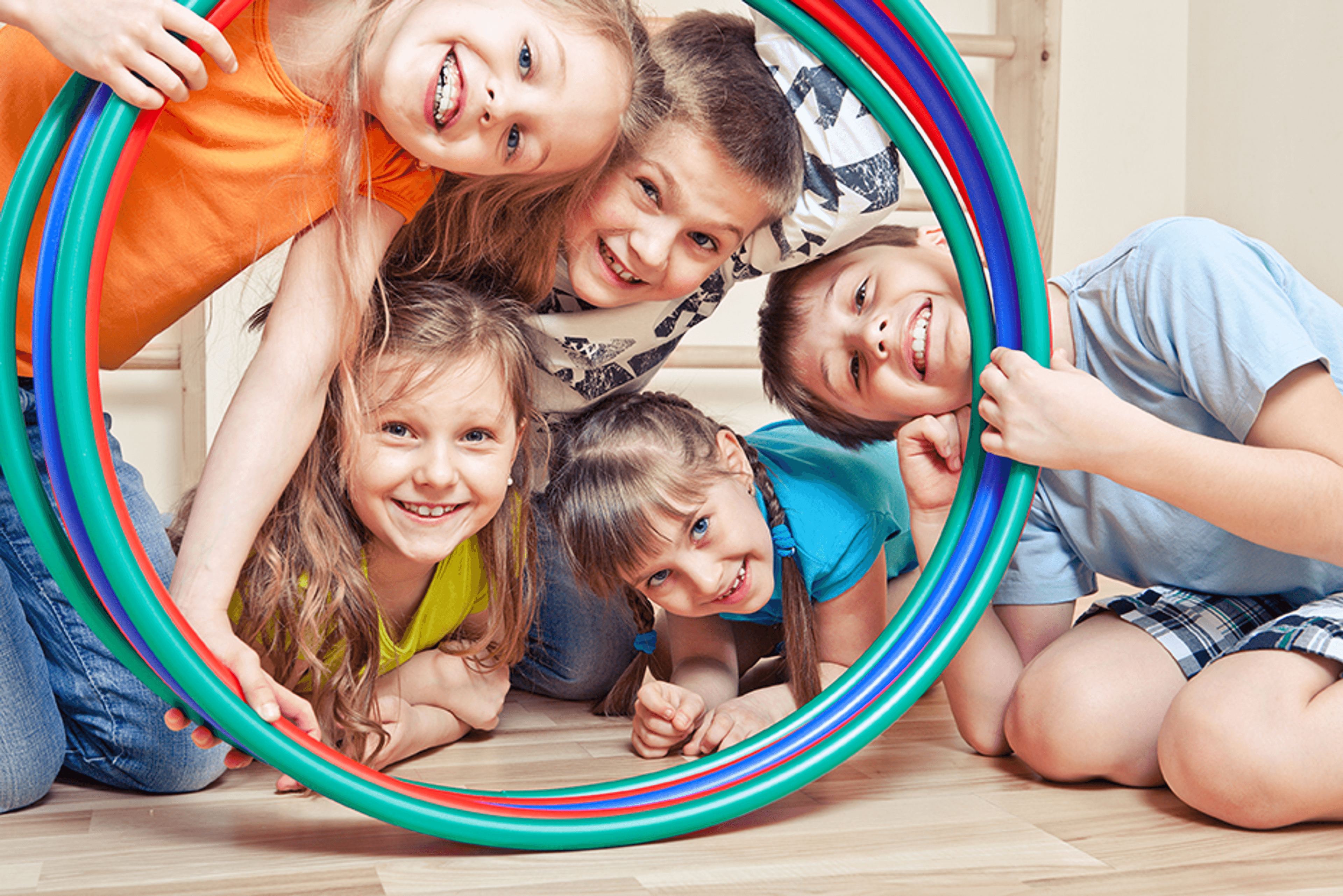A number of children posing with hula hoops